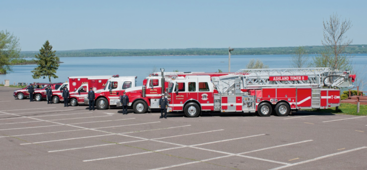 Row of fire trucks and firefighters
